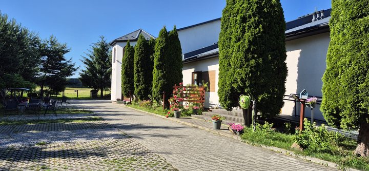 Budynek Zielonego Zacisza otoczony zielenią i kwiatami